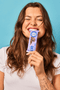 girl is holding and biting a Hungry Buddha triple chocolate bar